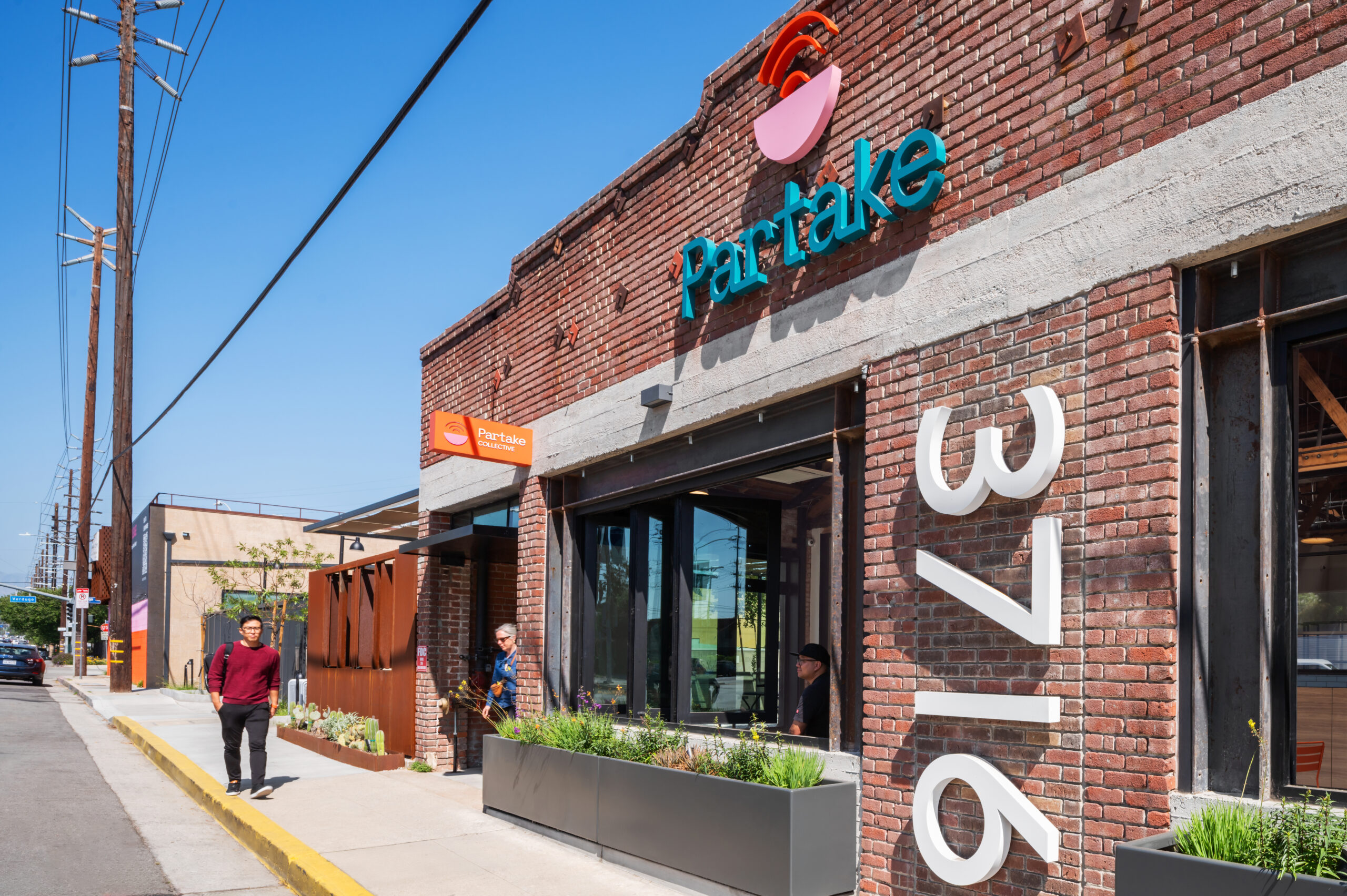 Exterior of Partake bakery with clear signage and outdoor seating.