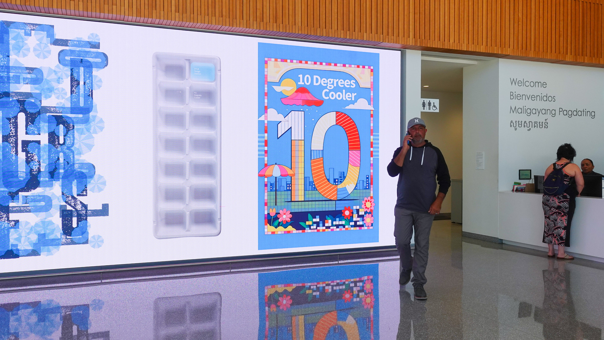 A man speaks near a colorful 10 Degrees Coffee promotional display in a modern setting.