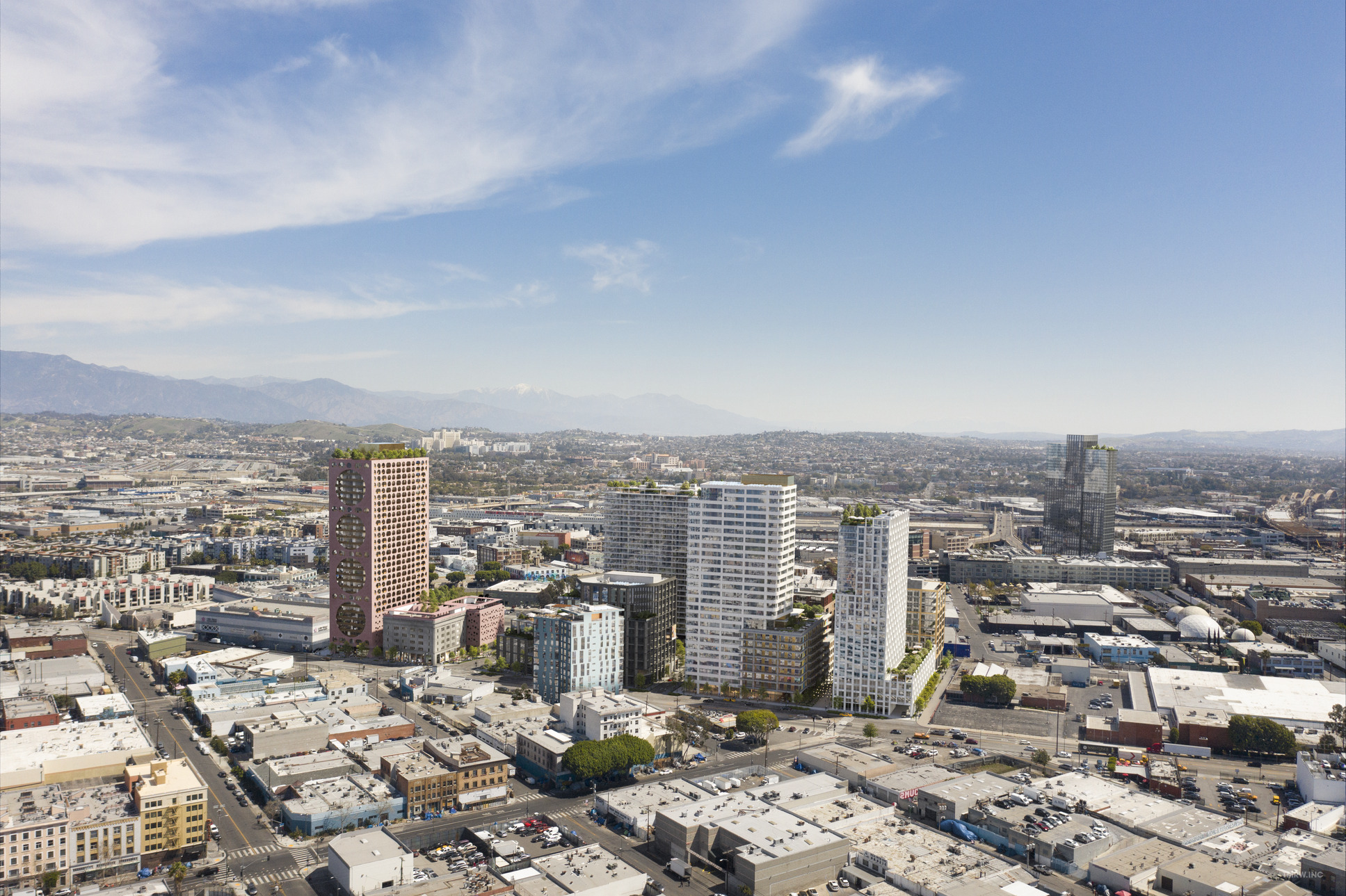 A sprawling urban cityscape under a partly cloudy blue sky.